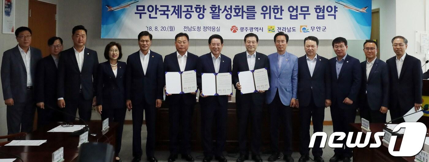 김영록(가운데) 전남도지사, 이용섭(오른쪽 여섯번째) 광주시장, 김산(왼쪽 여섯번째) 무안군수 등이 20일 오전 전남도청 정약용실에서 무안국제공항 활성화를 위한 광주 민간공항의 무안 국제공항 통합 업무협약을 체결하고 협약서를 들어보이고 있다. 2018.8.20/뉴스1 ⓒ News1 남성진 기자