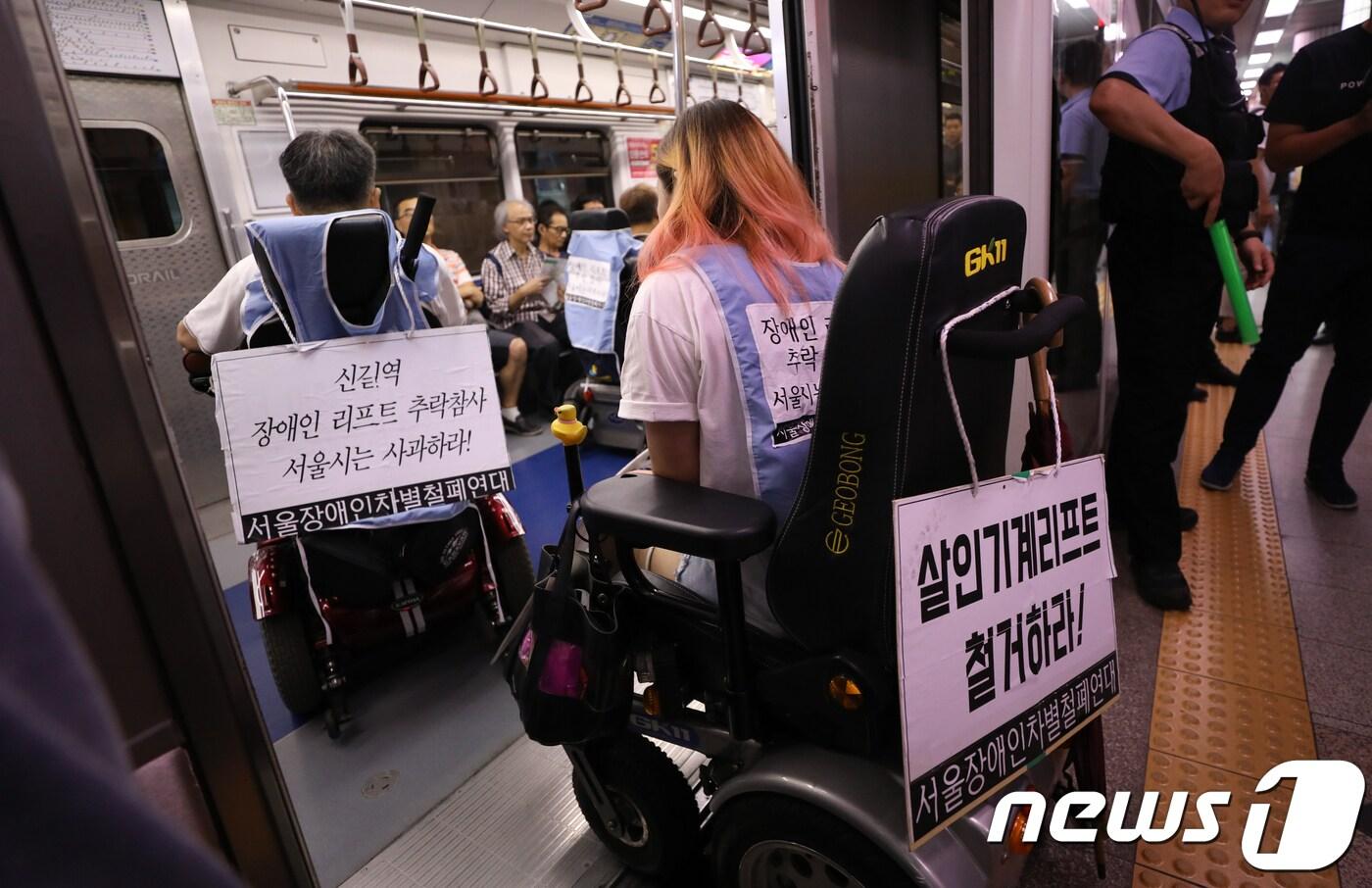 장애인차별철폐연대 회원들이 2018년 8월 서울지하철 1호선 시청역 승강장에서 열린 이동권 보장 촉구 기자회견을 마친 뒤 신길역 장애인 리프트 추락사건에 대한 사과와 지하철역 엘리베이터 설치를 요구하며 시위를 벌이고 있다. 2018.8.21/뉴스1 ⓒ News1 허경 기자