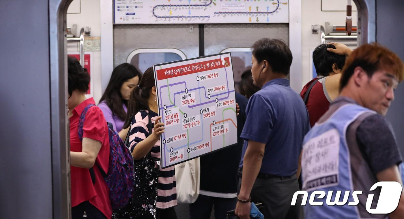 본문 이미지 - 장애인차별철폐연대 회원들이 21일 오후 서울 지하철 1호선 시청역 승강장에서 열린 이동권 보장 촉구 기자회견을 마친 뒤 신길역 장애인 리프트 추락사건에 대한 사과와 지하철역 엘리베이터 설치를 요구하며 시위를 벌이고 있다. 2018.8.21/뉴스1 ⓒ News1 허경 기자