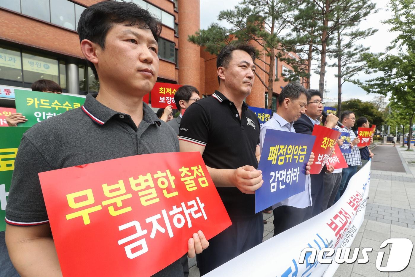 본문 이미지 - 지난 21일 서울 송파구 한국편의점산업협회 앞에서 편의점 전국가맹점주협의회 회원들이 편의점 제도개선을 촉구하며 기자회견을 하고 있다. 2018.8.21/뉴스1 ⓒ News1 성동훈 기자
