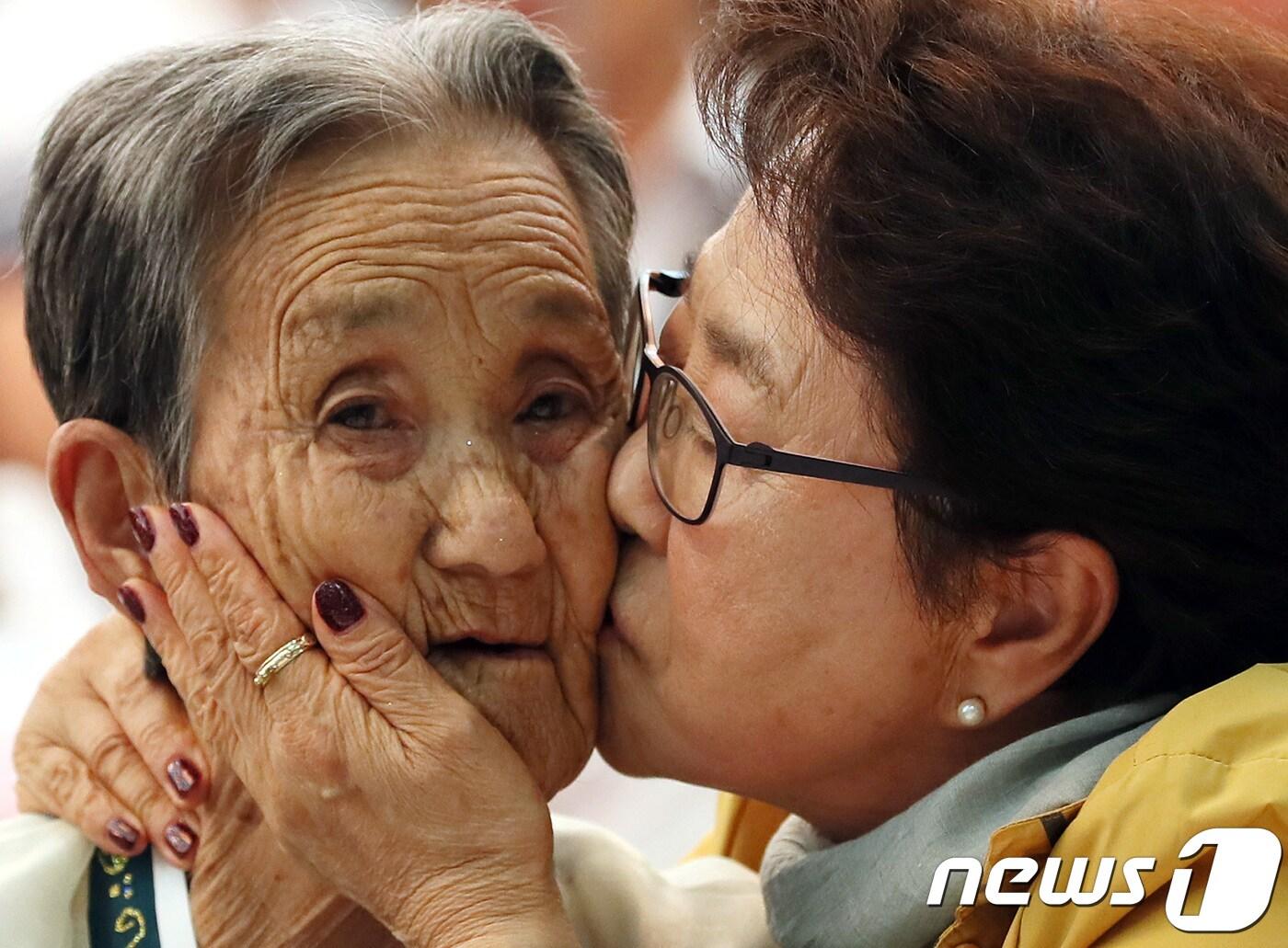 본문 이미지 - 제21차 이산가족 상봉행사 2회차 둘째날인 25일 오후 금강산 이산가족면회소에서 열린 단체상봉에서 남측의 박춘자(77)씨가 북측의 언니 박봉렬(85)할머니의 볼에 입을 맞추고 있다. 2018.8.25/뉴스1 ⓒ News1 뉴스통신취재단