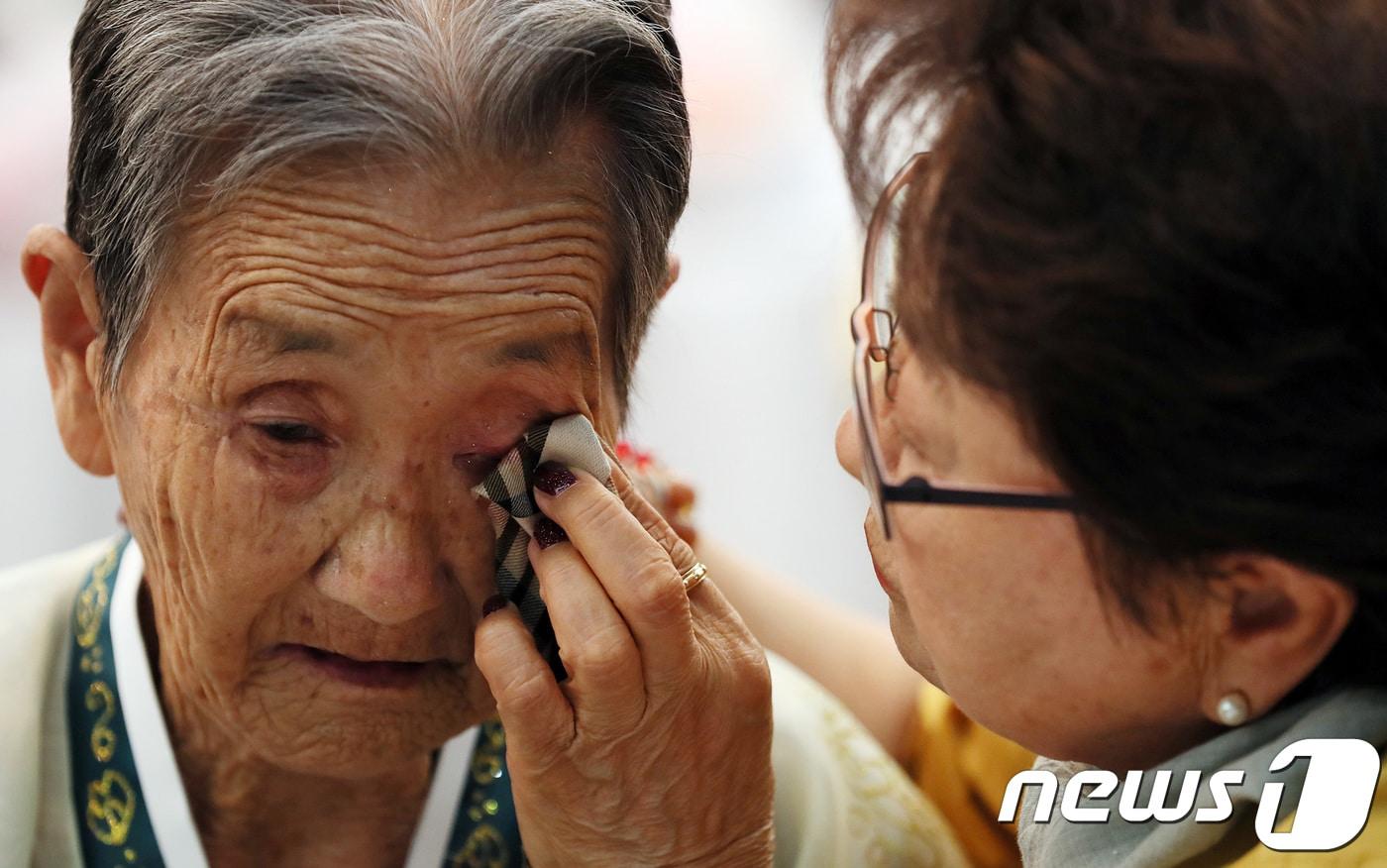 본문 이미지 - 제21차 이산가족 상봉행사 2회차 둘째날인 25일 오후 금강산 이산가족면회소에서 열린 단체상봉에서 남측의 박춘자(77)씨가 북측의 언니 박봉렬(85)할머니의 눈물을 닦아주고 있다. 2018.8.25/뉴스1 ⓒ News1 뉴스통신취재단