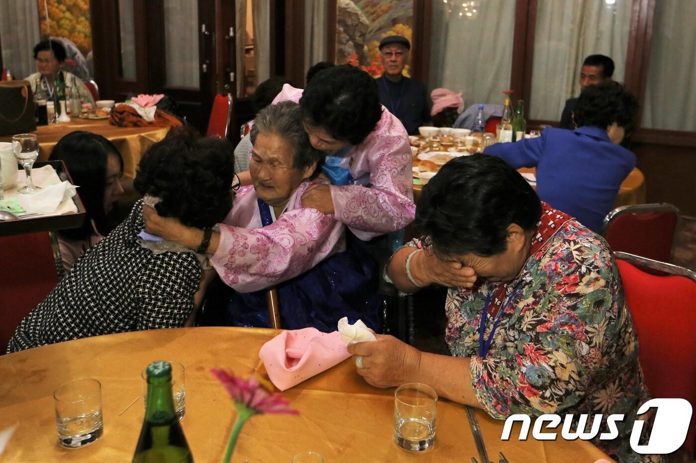 본문 이미지 - 제21차 이산가족 상봉행사 2회차 마지막날인 26일 오후 금강산호텔에서 열린 작별상봉 및 공동중식에서 남측 동생 강후남(79) 가족과 북측 언니 강호례(89)의 가족들이 대화하며 눈물을 흘리고 있다. 2018.8.26/뉴스1 ⓒ News1 뉴스통신취재단