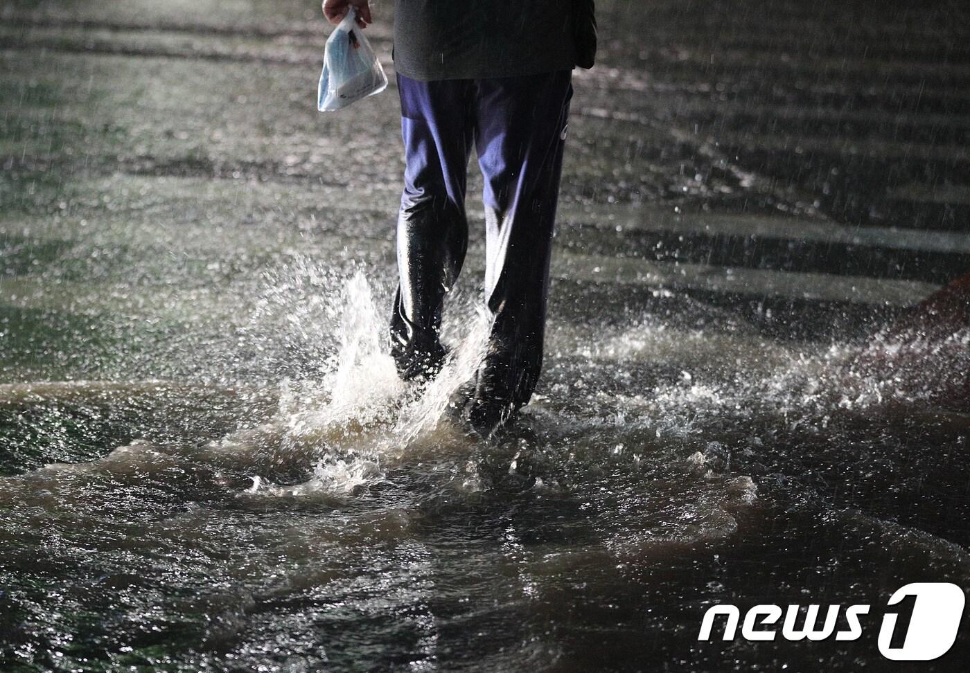 서울에 호우경보가 내려진 28일 오후 서울 종각역에서 한 시민이 물에 잠긴 횡단보도를 건너고 있다. 기상청은 이날 오후 7시40분을 기점으로 서울에 호우경보를 발령하고 오후7시50분에는 강원도 춘천과 경기도 가평, 남양주, 구리, 부천에 내려진 호우주의보를 호우경보로 격상했다. 2018.8.28/뉴스1 ⓒ News1 신웅수 기자