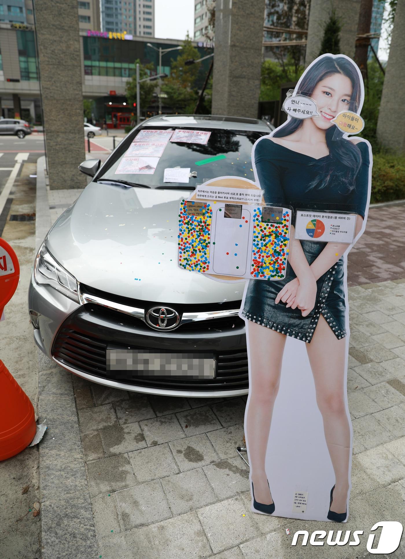 본문 이미지 - 30일 오후 인천시 연수구의 한 아파트단지 정문 인도에 방치된 승용차 옆에 가수 설현의 사진이 인쇄된 입간판이 세워져 있다. .2018.8.30/뉴스1 ⓒ News1 정진욱 기자