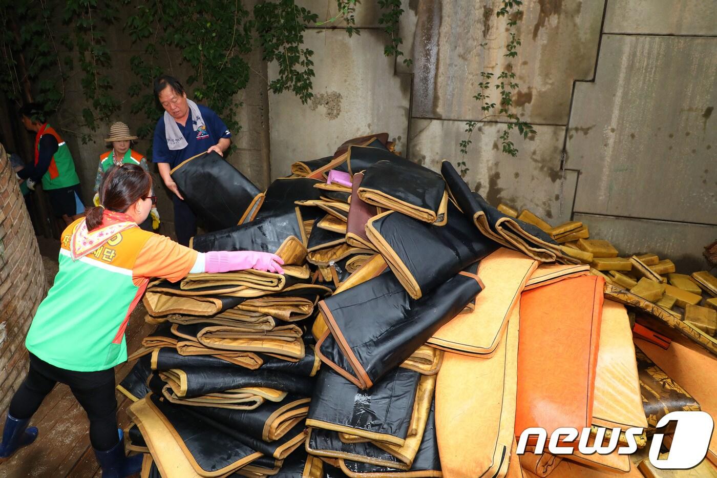 본문 이미지 - 전날 내린 폭우로 강원 영동 지역 곳곳에 피해가 발생했다. 7일 속초시 교동 한 찜질방에서 자율방재단이 침수피해 복구 작업을 하고 있다. 이날 오전부터 속초, 철원, 화천, 양구, 정선, 인제 등 강원도 자율방재단 50여명이 침수 피해지역 곳곳에 투입됐다. 2018.8.7/뉴스1 ⓒ News1 고재교 기자