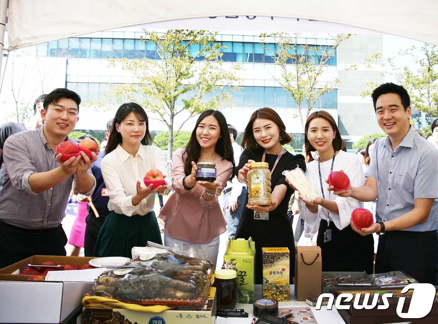 본문 이미지 - 삼성전자 임직원들이 삼성전자 자매마을인 '황둔송계마을'에서 생산된 제품들을 들어보이고 있다. ⓒ News1