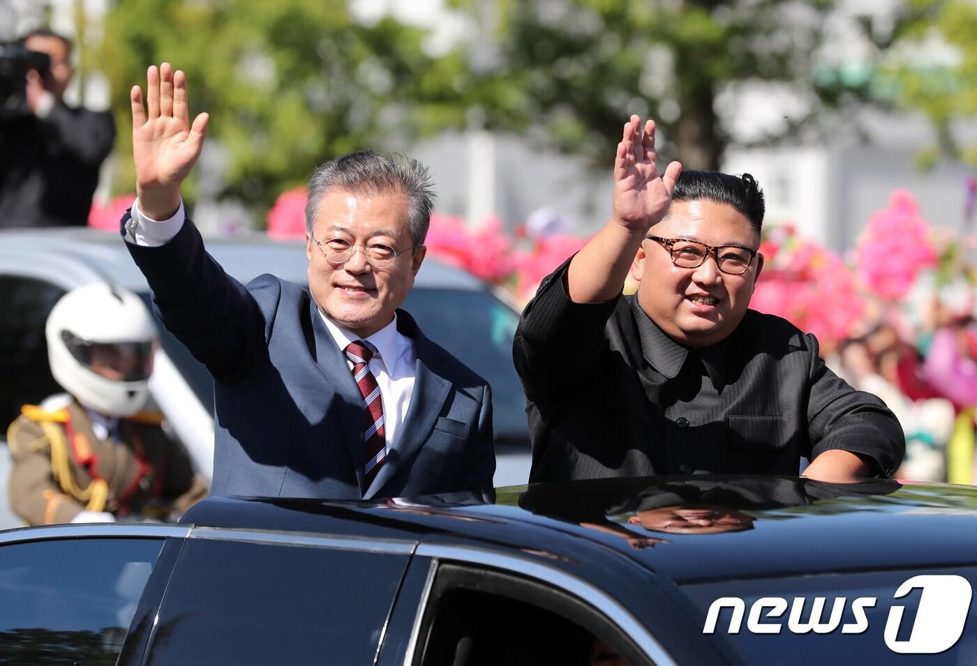 본문 이미지 - 문재인 대통령과 김정은 북한 국무위원장이 지난 2018년 9월18일 평양 시내를 카퍼레이드 하며 환영하는 평양 시민들에게 손을 들어 인사하고 있다. 2018.9.18/뉴스1 ⓒ News1 평양사진공동취재단