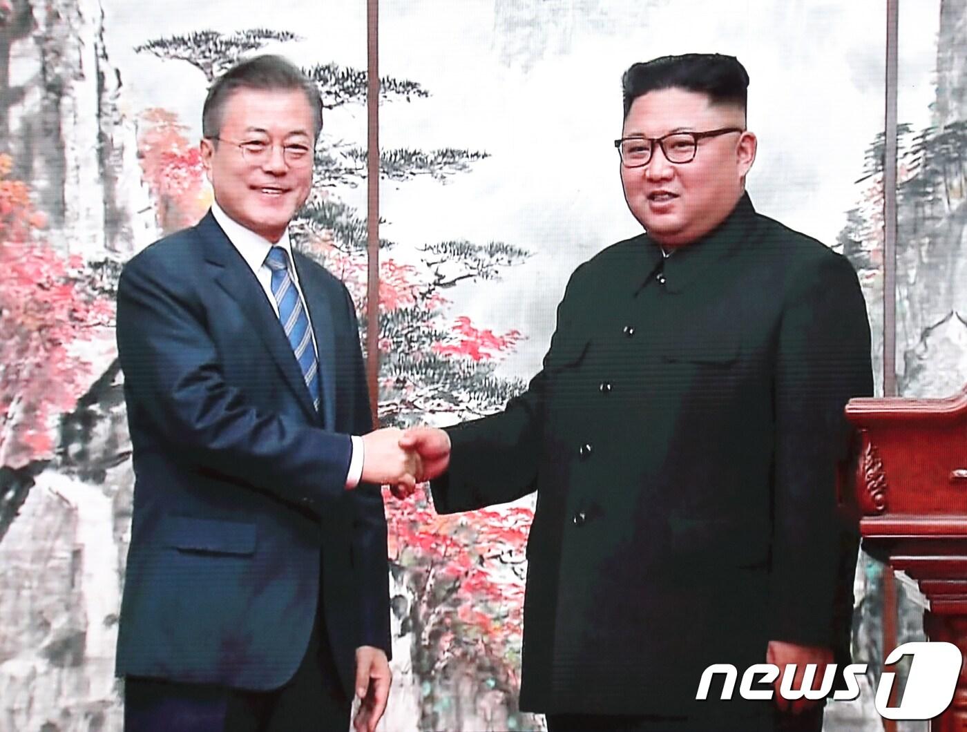 본문 이미지 - 문재인 대통령과 김정은 북한 국무위원장이 19일 평양 백화원 영빈관에서 남북정상 공동 기자회견을 마치고 악수하는 모습이 서울 동대문 디자인플라자 평양남북정상회담 프레스센터에 생중계 되고 있다.2018.9.19/뉴스1 ⓒ News1 송원영 기자