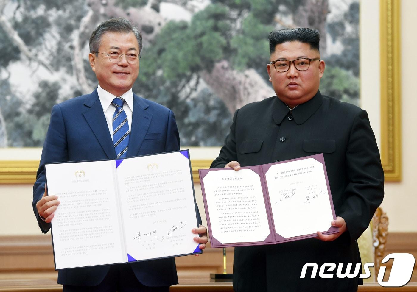 본문 이미지 - 문재인 대통령과 김정은 북한 국무위원장이 9·19 평양남북정상회담 당시 평양 백화원 영빈관에서 평양공동선언문에 서명한 후 합의서를 들어보이고 있다. 2018.9.19/뉴스1 ⓒ News1 평양사진공동취재단