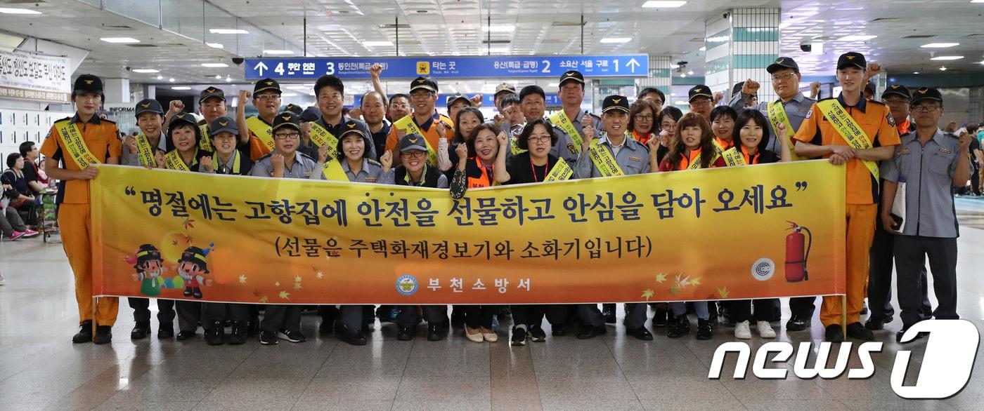 본문 이미지 - 이재열 경기도재난안전본부장(두번째줄 왼쪽에서 다섯번째)이 21일 부천역사에서 부천소방의용대와 함께 한가위 안전 캠페인을 한 후 기념사진을 촬영하고 있다. 2018.9.21/뉴스1 ⓒ News1 정진욱 기자