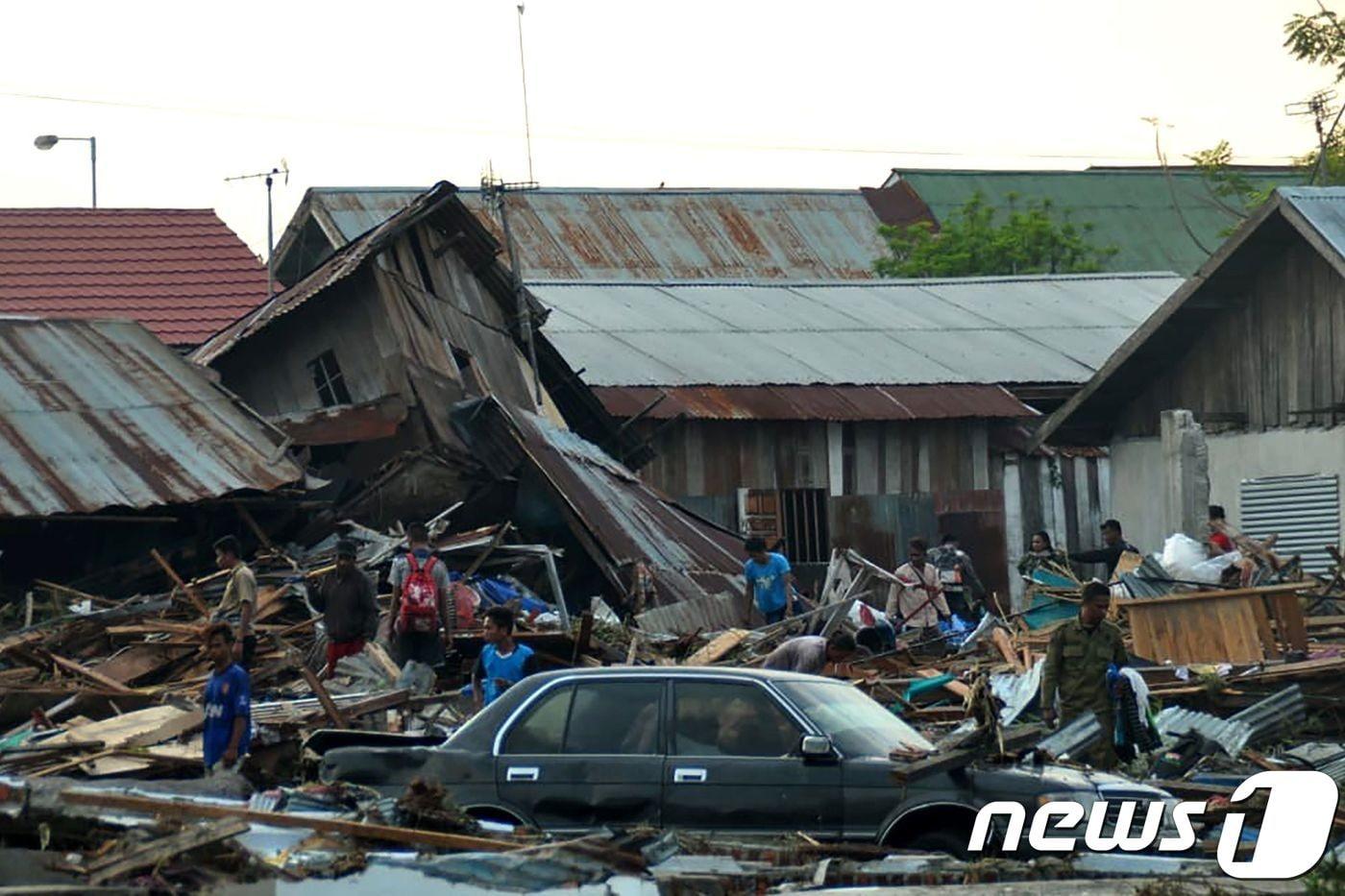 본문 이미지 - 29일 인도네시아 중부 술라웨시 섬 팔루에서 주민들이 강진과 쓰나미로 무너진 건물 잔해 속에서 생존자를 찾고 있다. 현지 언론은 지난 28일 술라웨시 섬에서 발생한 규모 7.5의 강진과 쓰나미로 현재까지 최소 832명이 숨졌다고 밝혔다. 9AFP/뉴스1 ⓒ AFP=뉴스1