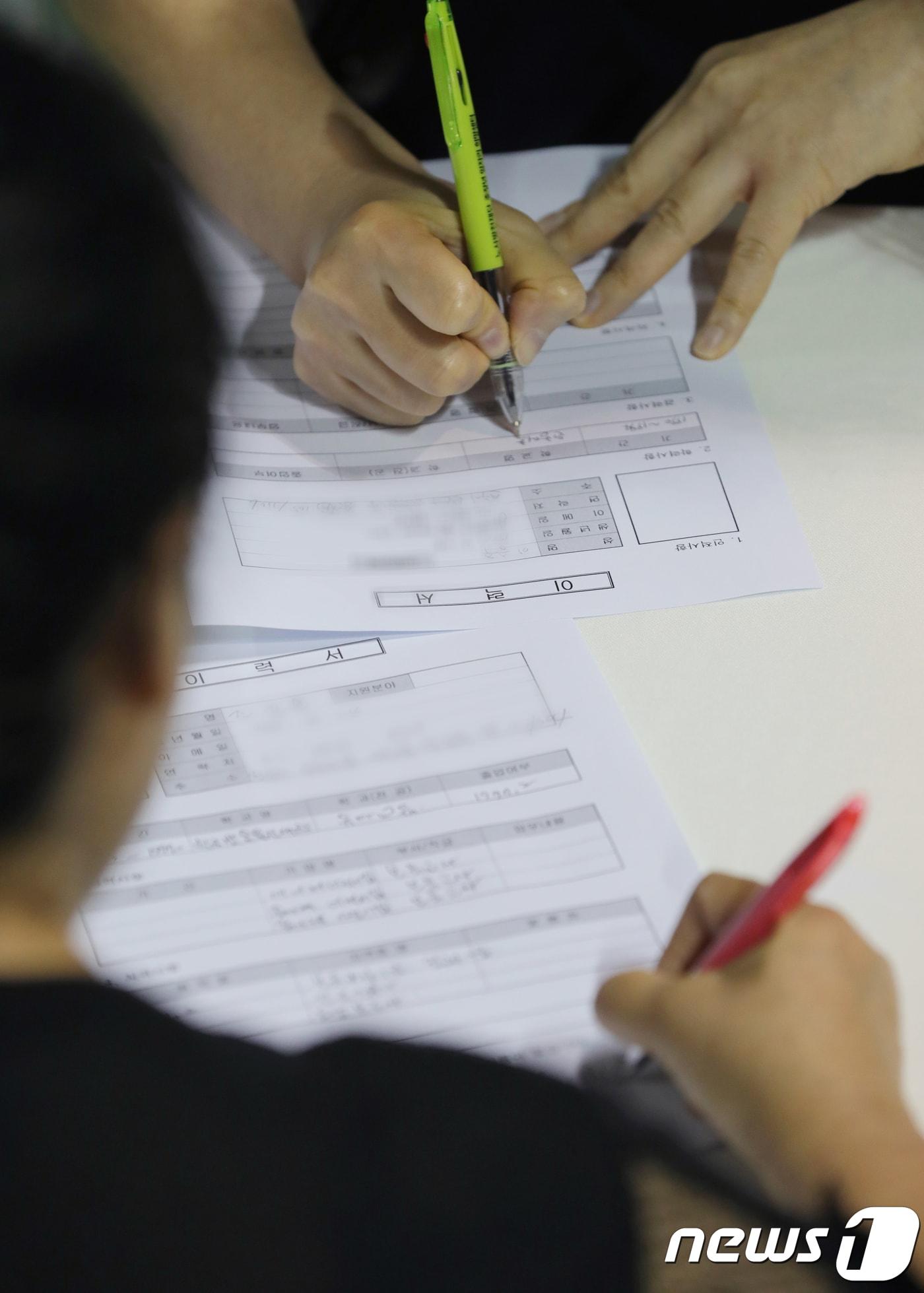 본문 이미지 -  일자리박람회를 찾은 구직자들이 이력서를 작성하고 있다. /뉴스1 ⓒ News1 문요한 기자
