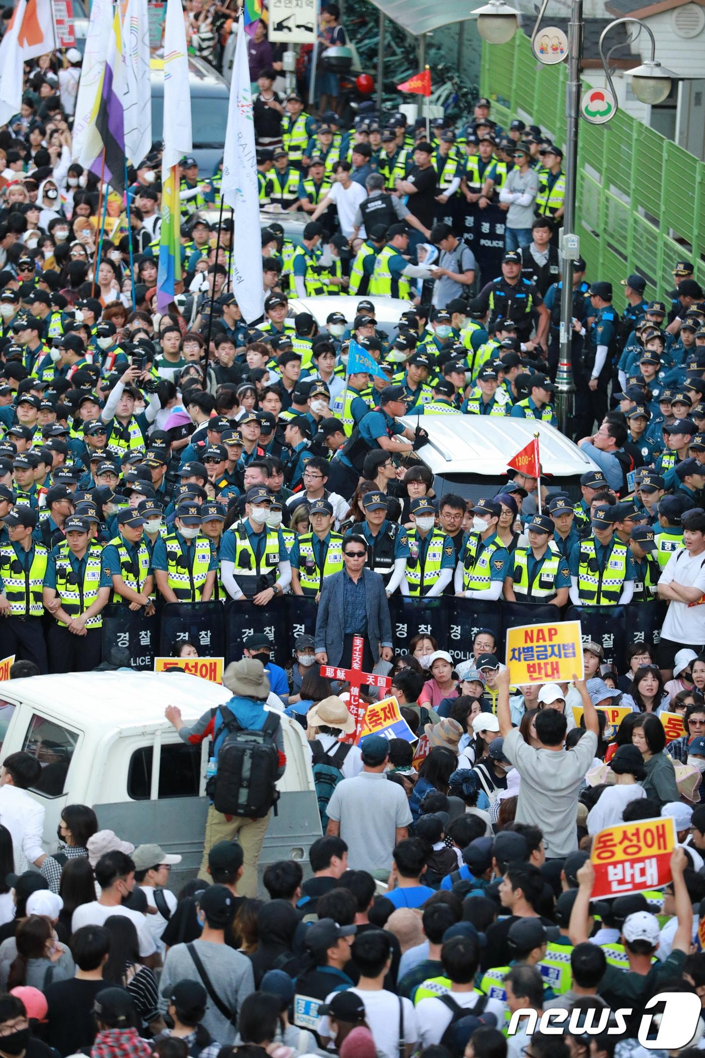 본문 이미지 - 8일 오후 인천시 동인천역 북광장에서 열린 인천퀴어문화축제에서 참가자들이 행진을 시도하자 반대집회 참가자들이 막아서며 대치하고 있다.2018.9.8/뉴스1 ⓒ News1 정진욱 기자