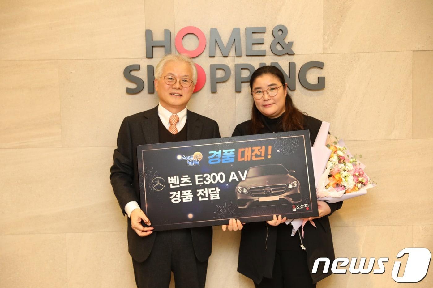 본문 이미지 - 21일 오전 서울 마곡동 본사에서 진행된 경품 증정식에서 최종삼 홈앤쇼핑 사장과당첨자가 기념 촬영을 하고 있다.ⓒ 뉴스1
