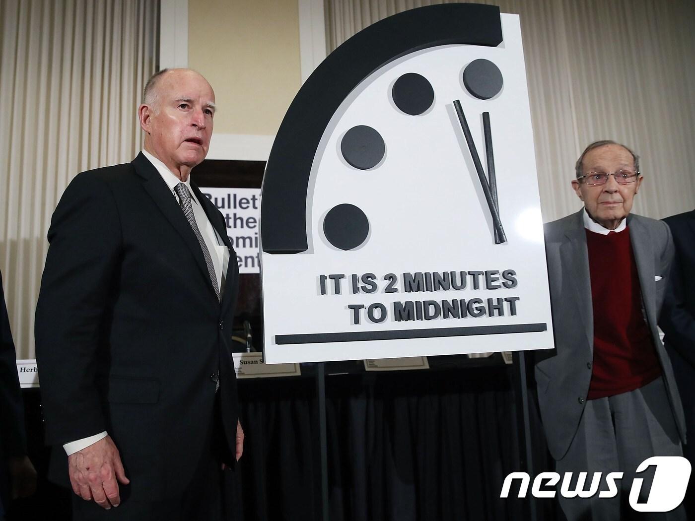 본문 이미지 - 미국 핵과학자회가 발표한 운명의 날 시계 앞에서 포즈를 취하고 있는 제리 브라운 전 캘리포니아 주지사. ⓒ AFP=뉴스1