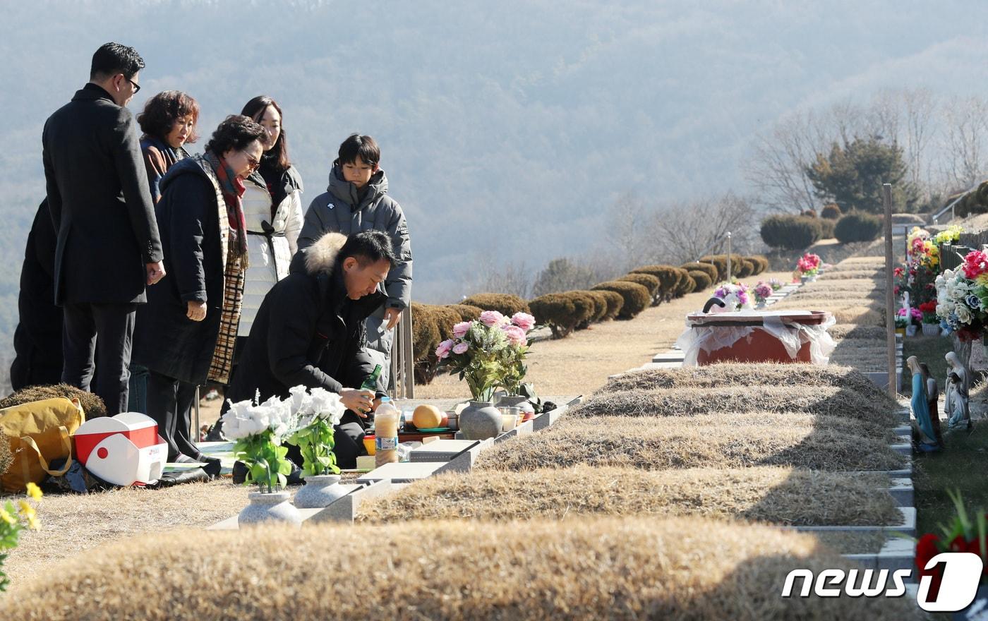 본문 이미지 - 설 명절을 일주일 앞둔 지난달 27일 경기도 용인시 처인구 용인천주교공원묘지에서 가족단위 성묘객들이 조상의 묘를 찾아 성묘하고 있다. /뉴스1 ⓒ News1 조태형 기자