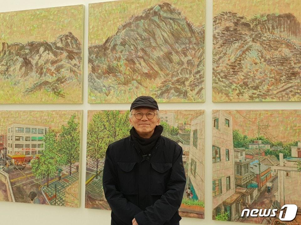 본문 이미지 - 민정기 작가가 29일 개인전이 열리고 있는 국제갤러리에 걸린 자신의 작품 앞에서 포즈를 취하고 있다ⓒ 뉴스1
