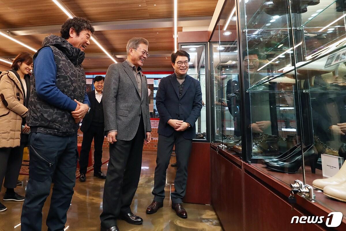 본문 이미지 - 문재인 대통령이 3일 서울 성동구 성수 수제화 희망플랫폼을 방문해 정원오 성동구청장, 유홍식 드림제화 대표에게 희망플랫폼 1층 쇼룸에 전시된 수제화에 대해 설명을 듣고 있다. (청와대 제공) 2019.1.3/뉴스1