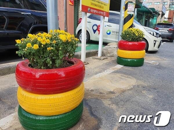 본문 이미지 - 가장동 행정복지센터 앞 불법주·정차 구역에 조성된 폐타이어 재활용 ‘신호등 화분’ⓒ 뉴스1