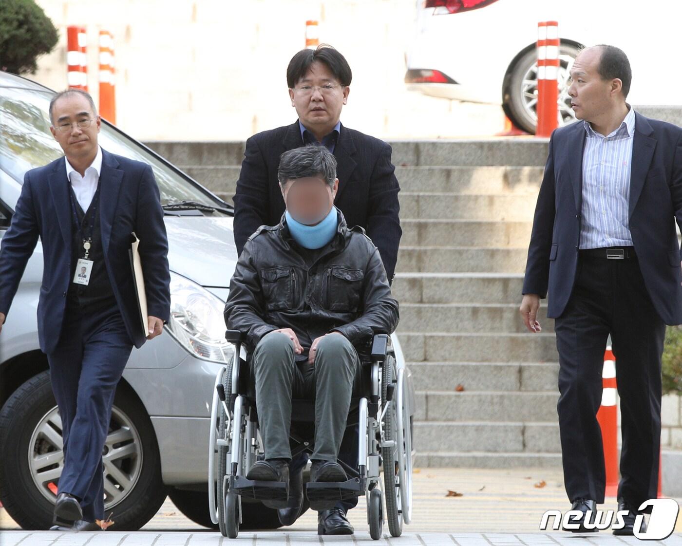 본문 이미지 - '웅동학원 비리' 의혹을 받고 있는 조국 법무부장관 동생 조모씨가 휠체어를 타고 법원으로 이동하는 모습. 2019.10.31/뉴스1 ⓒ News1 신웅수 기자