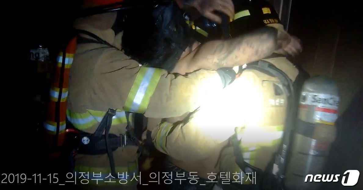 본문 이미지 - 의정부시의 한 숙박업소에서 불이 난 가운데 구조대가 복도에 쓰러진 남성을 구조하는 모습 (경기북부소방재난본부 제공) ⓒ 뉴스1