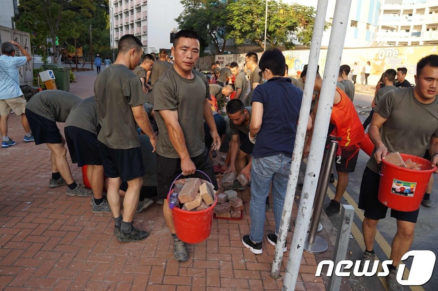 본문 이미지 - 16일 홍콩 주둔 인민군이 부대 인근 도로 복구에 나서고 있다. ⓒ AFP=뉴스1 ⓒ News1 박형기 기자