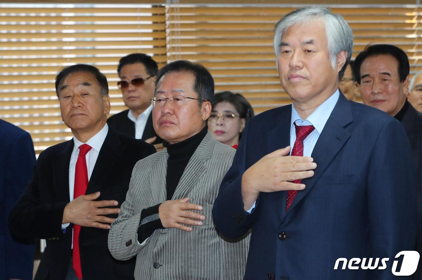 홍준표 대구시장은 자신에게 막말을 퍼부은 극우 성향의 전광훈 사랑제일교회 목사를 향해 "목회자가 목회자 답지 않게 욕설을 입에 달고 다니면서 자제력을 잃고 거친 말을 함부로 내뱉는 것은 참으로 유감스러운 일"이라고 비판했다. 사진은 2019년 11월 당시 홍준표 자유한국당 전 대표(가운데)와 전광훈 목사(오른쪽), 이재오 전 의원(왼쪽)이 보수단체 대규모 집회 평가 세미나에 참석해 국기에 대한 경례를 하는 모습. 2019.11.20/뉴스1 ⓒ News1 자료 사진