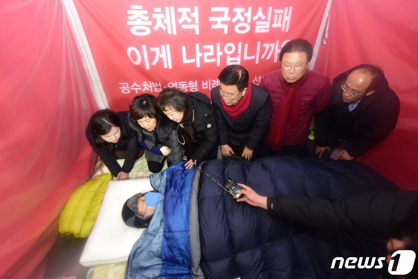 본문 이미지 - 자유한국당 최고위원들을 비롯한 지도부가 26일 오후 서울 청와대 분수대에서 7일째 단식투쟁인 황교안 대표에게 단식 중단을 설득하고 있다. 2019.11.26/뉴스1