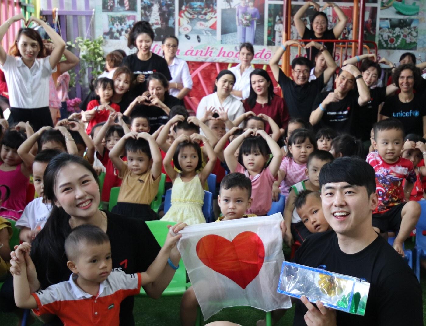 본문 이미지 - 아시아나항공이 5일 유니세프와 베트남 호찌민 '타오 응우옌 샨(Thao Nguyen Xanh) 센터'를 방문해 영유아 보육지원 사업을 실시했다. 행사에 참석한 아시아나항공 임직원들이 보육시설 아동들과 함께 기념촬영을 하고 있다. (아시아나항공 제공)ⓒ 뉴스1