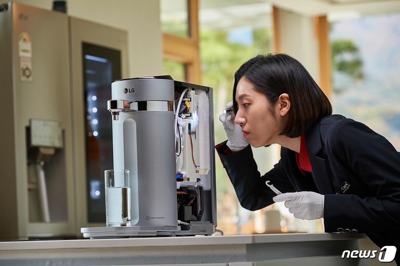본문 이미지 - LG전자 케어솔루션 매니저가 LG 퓨리케어 정수기의 직수관을 무상교체하면서 내부 부품까지 꼼꼼하게 점검하고 있다.(LG전자 제공)2019.11.07/뉴스1 ⓒ 뉴스1