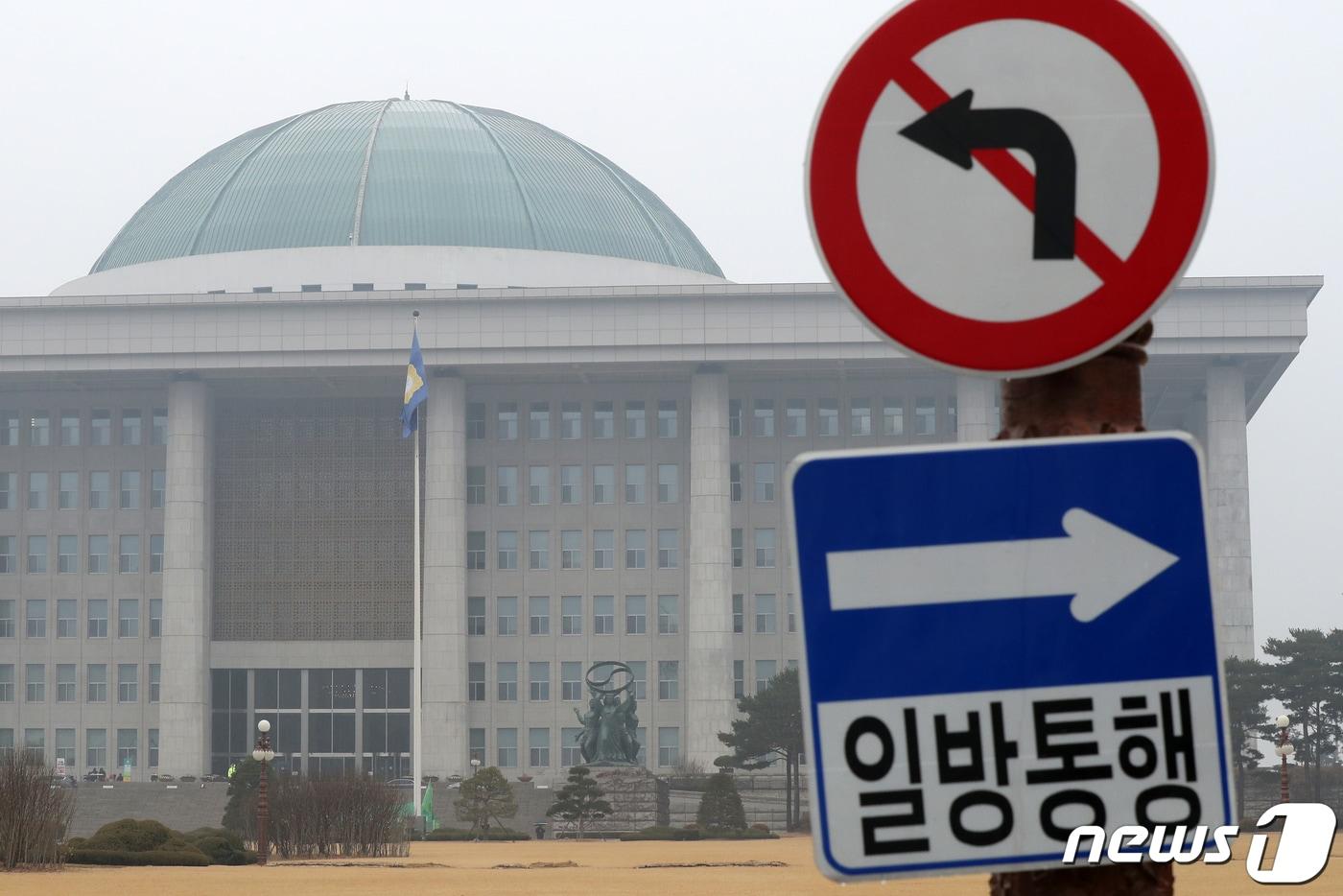 서울 여의도 국회의사당 출입로 앞에 설치된 &#39;일방통행&#39; 표지판 너머로 국회가 바라보이고 있다. 2019.12.1/뉴스1 ⓒ News1 민경석 기자
