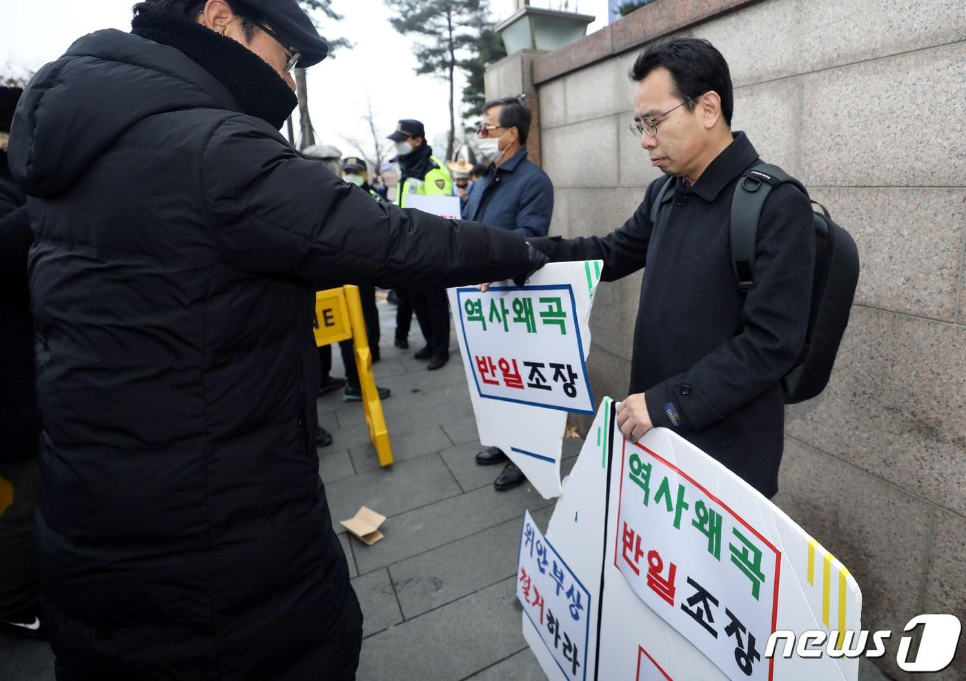 본문 이미지 - '반일종족주의' 저자 이우연 낙성대경제연구소 연구위원이 지난해 12월서울 종로구 옛 일본대사관 앞에서 수요시위 중단과 소녀상 철거를 주장하며 한 시민이 걷어차 부서진 피켓을 든 채 1인 시위를 벌이고 있다. 2019.12.11/뉴스1 ⓒ News1 이동해 기자