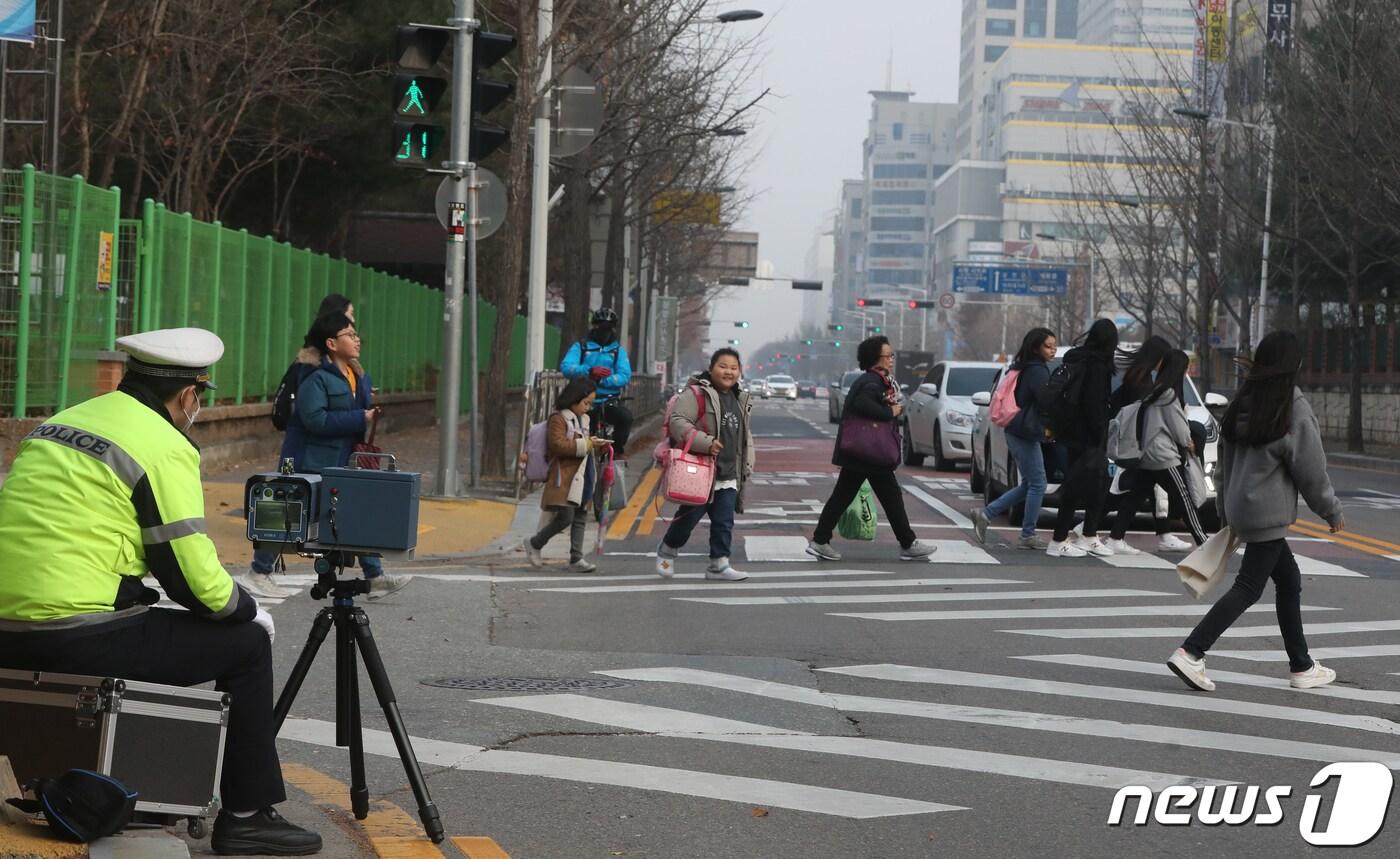 본문 이미지 - 스쿨존 어린이 교통안전 강화를 위한 '민식이법'이 국회를 통과한 가운데 지난 12월 대전 서구 둔산 초등학교 앞 스쿨존에서 둔산 경찰서 교통안전계 경찰이 과속단속 카메라를 설치해 과속 차량을 단속을 하고 있다. . 2019.12.11/뉴스1 ⓒ News1 주기철 기자