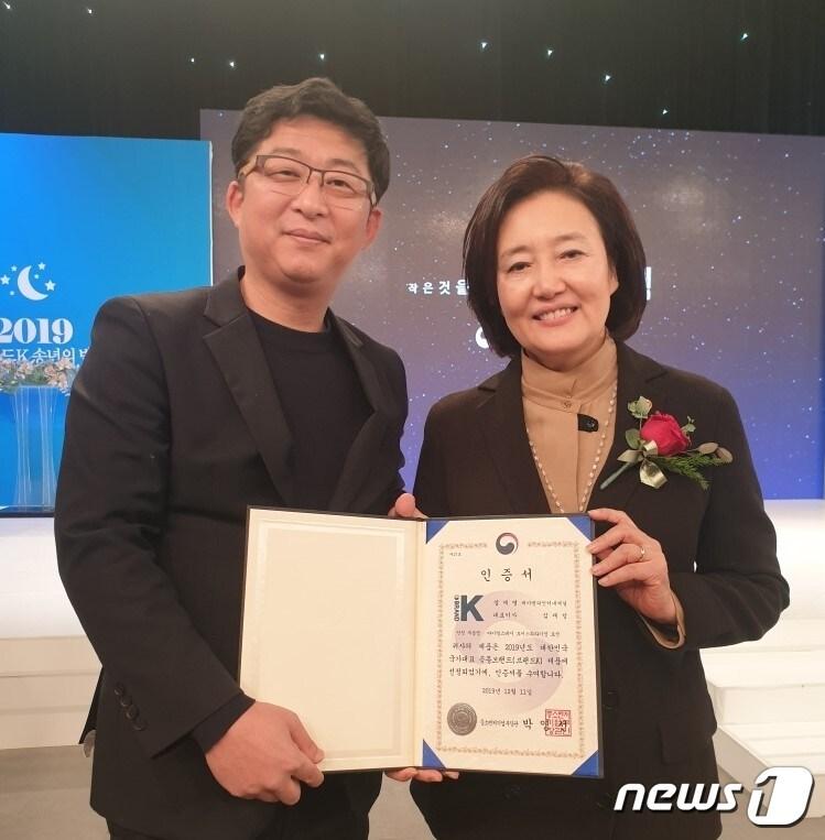 본문 이미지 - 박영선 중소벤처기업부 장관(오른쪽)과 심재성 ㈜제이앤피인터내셔널 대표가 지난 11일 서울 마포구 공영쇼핑에서 열린 '브랜드K 송년의 밤' 행사장에서 브랜드K 인증서를 들고 기념 사진 촬영을 했다.  (심재성 대표 제공)  ⓒ 뉴스1