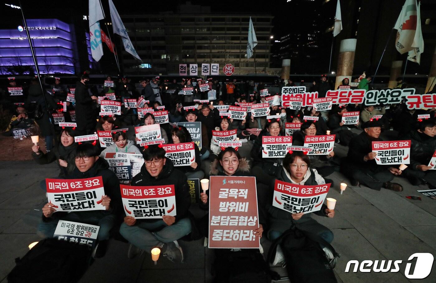본문 이미지 - 14일 오후 서울 광화문광장에서 열린 미국의 방위비분담금 강요 규탄 촛불집회 참석자들이 구호를 외치고 있다. 2019.12.14/뉴스1 ⓒ News1 박세연 기자