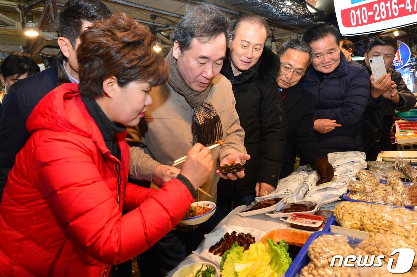 본문 이미지 - 이낙연 국무총리가 28일 오전 경북 포항시 북구 흥해읍 전통시장에서 상인이 건네 준 과메기를 맛보고 있다. 이 총리는 지진 피해 이재민 이주시설과 지진트라우마 센터, 흥해전통시장을 방문해 지진으로 힘들어하고 있는 시민들을 격려했다. 2019.12.28/뉴스1 ⓒ News1 최창호 기자