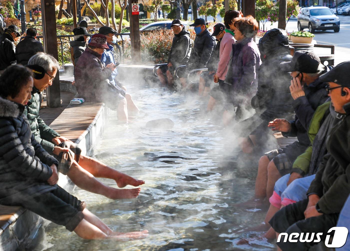 본문 이미지 - 지난해 겨울, 대전 유성구 유성온천 족욕체험장을 찾은 시민들이 따뜻한 온천수에 발을 담그고 몸을 녹이고 있다. ⓒ News1 