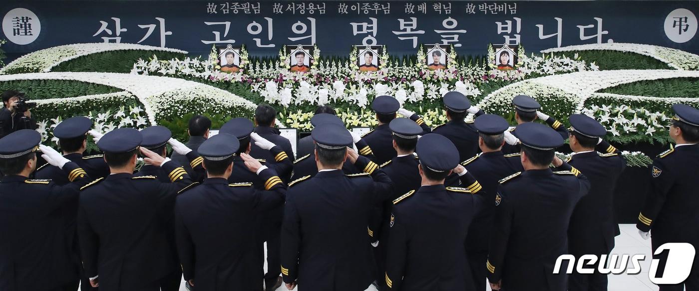 본문 이미지 - 6일 대구 달서구 계명대학교 동산병원 백합원에 마련된 독도 소방헬기 추락사고 순직 중앙119구조본부 소속 소방항공대원 5명의 합동분향소에서 송민헌 대구지방경찰청장 등 경찰관들이 경례를 하고 있다. 이날부터 닷새간 합동 장례를 치르는 소방항공대원 5명은 김종필 기장(46), 이종후 부기장(39), 서정용 정비실장(45), 배혁 구조대원(31), 박단비 구급대원(29·여)이다. 2019.12.6/뉴스1 ⓒ News1 공정식 기자