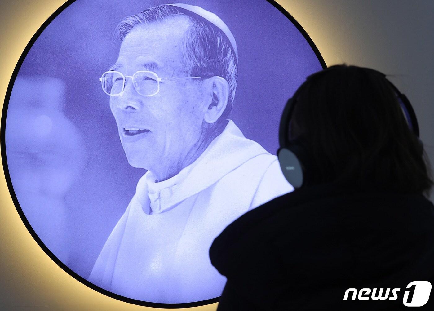 본문 이미지 - 김수환 스테파노 추기경 선종 10주기를 앞둔 11일 오후 서울 중구 명동성당 내 1898광장에서 열린 추모 사진전을 찾은 시민들이 김 전 추기경의 육성이 담긴 오디오를 듣고 있다. 2019.2.11/뉴스1 ⓒ News1 이재명 기자