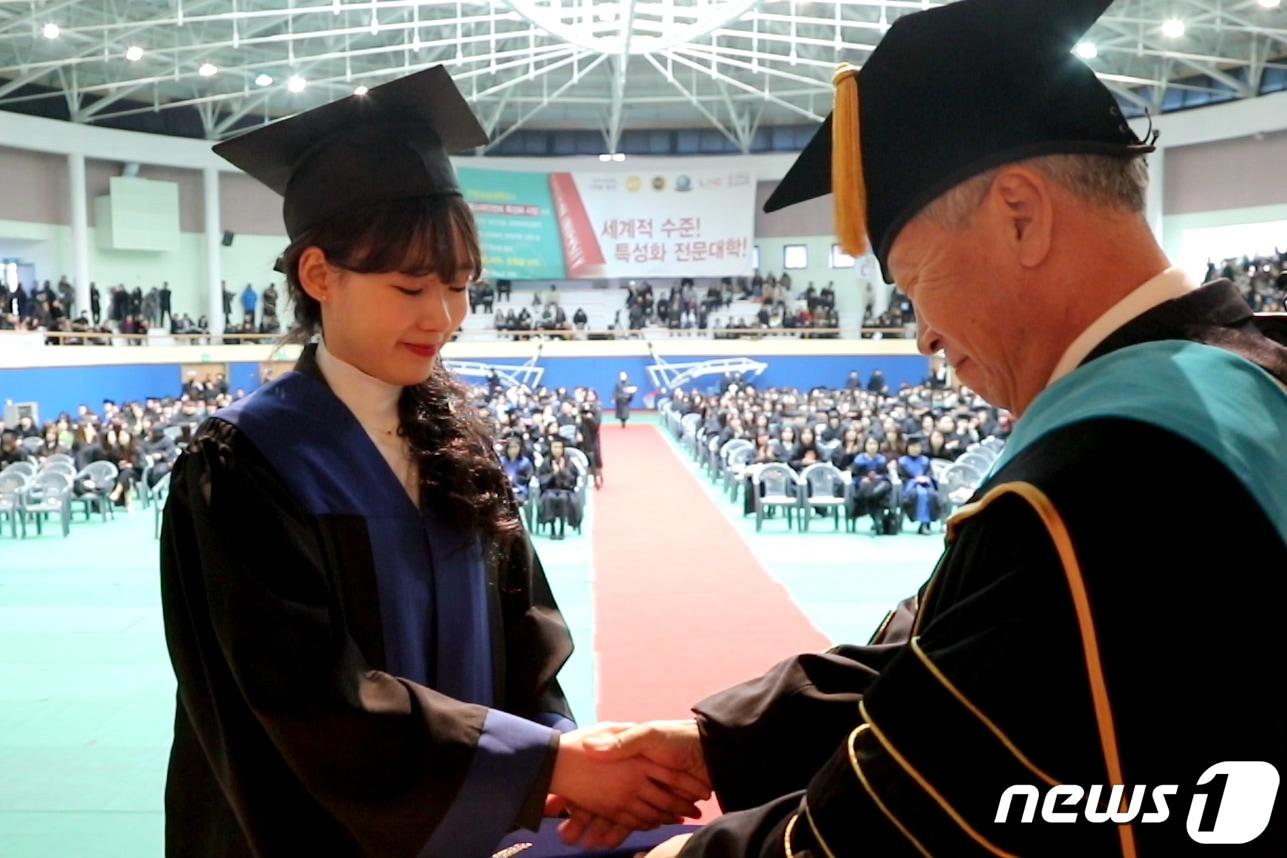본문 이미지 - 13일 오전 강원 춘천시 한림성심대학교 일송체육관에서 열린 학위수여식에서 우형식 총장이 졸업생에게 학위를 수여하고 악수를 하고 있다. (한림성심대학교 제공) 2019.2.13/뉴스1 ⓒ News1 김경석 기자