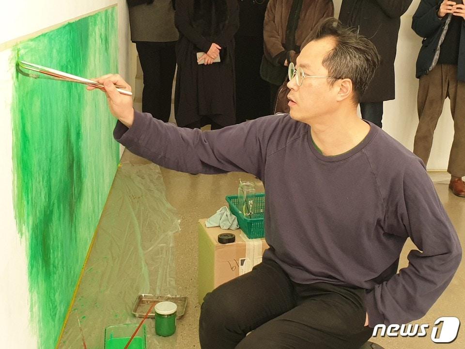 본문 이미지 - 백현진이 14일 개인전이 열리고 있는 PKM갤러리에서 퍼포먼스 '뮤지컬:영원한 봄'을 하고 있다. ⓒ 뉴스1