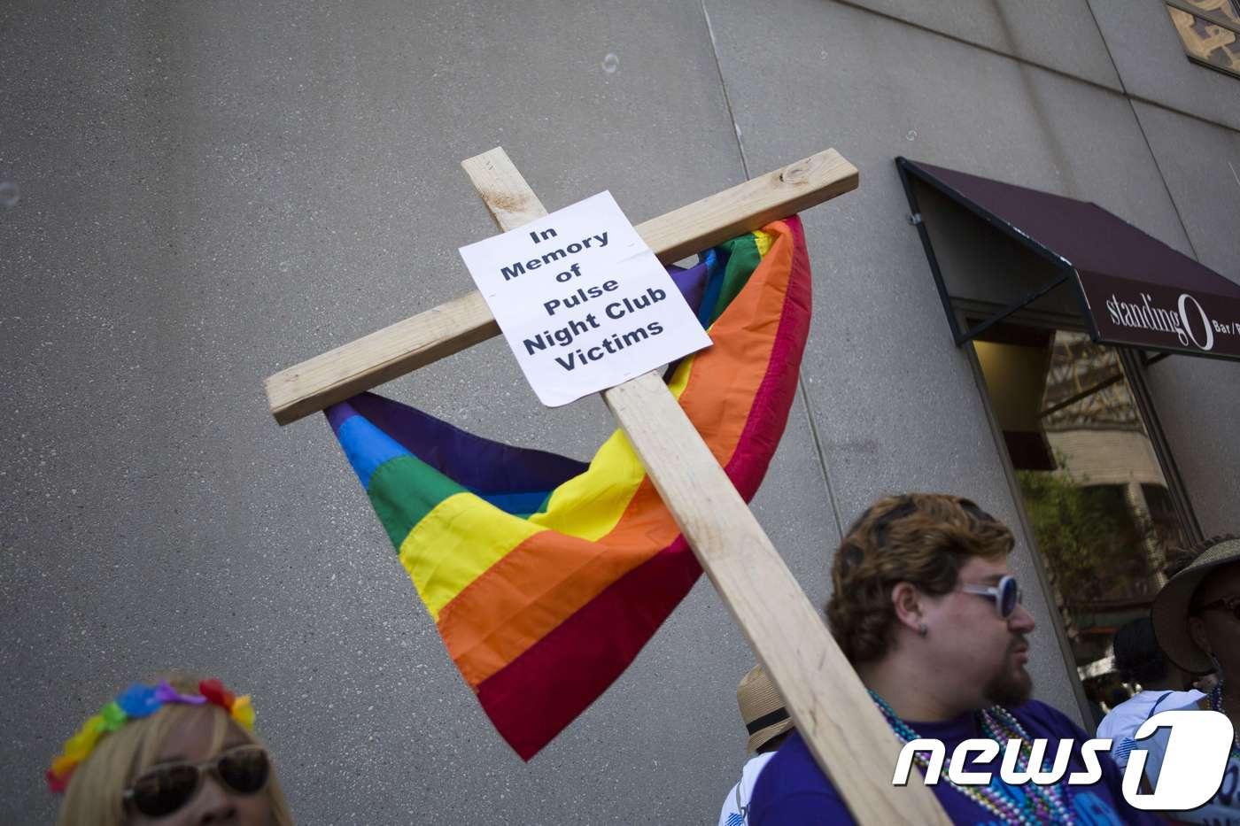 2016년 미국의 한 게이 퍼레이드에서 참가자가 십자가를 들고 행진하고 있다. <자료사진> ⓒ AFP=뉴스1