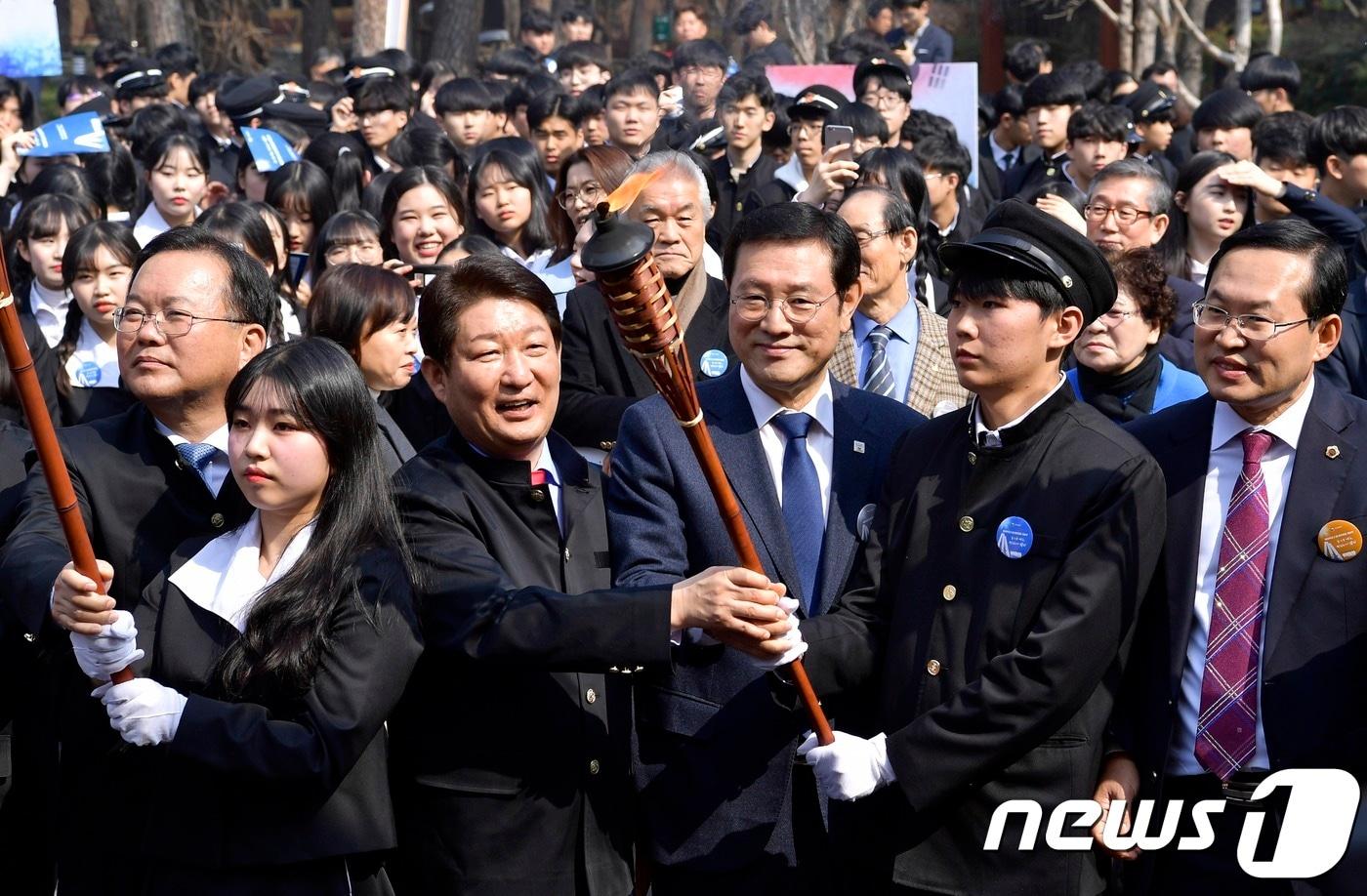 본문 이미지 - 이용섭 광주광장과 권영진 대구시장이 지난 2월28일 대구 2·28기념 중앙공원에서 열린 2·28민주운동 재현행사에서 '민주의 횃불'을 함께 점화한 뒤 학생대표들과 손을 맞잡고 있다 ⓒ 뉴스1