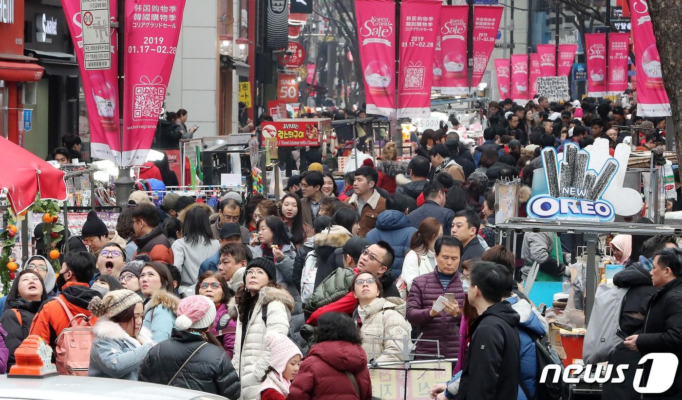 본문 이미지 - 춘절을 맞아 한국을 찾은 중국인 관광객들이 서울 명동에 걸린 코리아 그랜드 세일 안내 현수막을 따라 걷고 있다. .2019.2.6 ⓒ 뉴스1 이종덕 기자