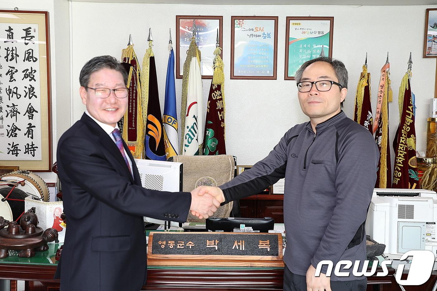 러시아 모스크바물리기술대를 수석 졸업하고, 러시아 항공우주 전문잡지인 ‘자유로운 비행’의 표지 인물로도 선정된 공근식씨(49·오른쪽)가 지난 7일 고향인 충북 영동군을 찾아 박세복 군수와 악수하고 있다.(영동군 제공).2019.02.08.ⓒ 뉴스1