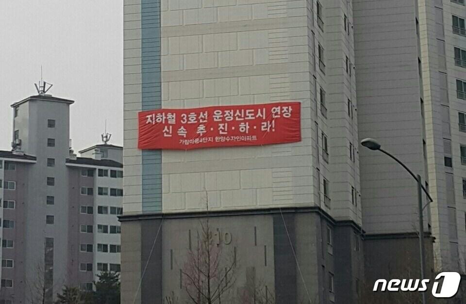 본문 이미지 - 파주 운정신도시 가람마을4단지에 걸려 있는 '3호선 연장 조기 착공' 내용의 대형 현수막. /사진제공=운정연 ⓒ 뉴스1
