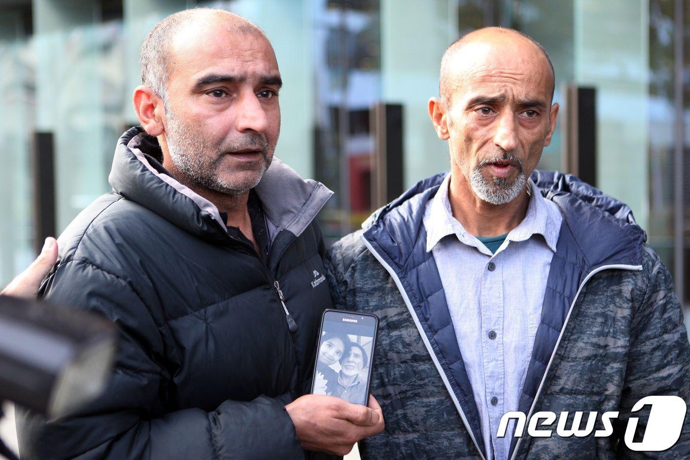 본문 이미지 - 다우드 나비의 아들들인 야마(왼쪽)와 오마르가 자신의 아버지의 사진을 보여주며 언론과 인터뷰하고 있다. ⓒ AFP=뉴스1