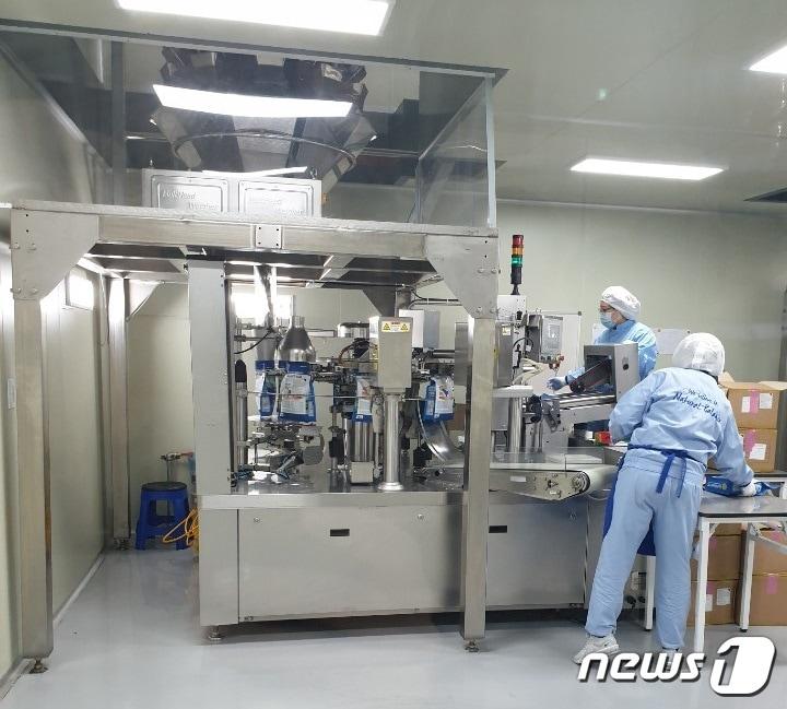 본문 이미지 - 2층에서 1층으로 바로 연결되는 기계를 통해 사료가 내려오면 바로 소분 포장지에 담긴다. ⓒ 뉴스1