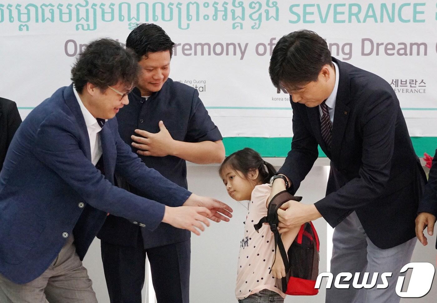 본문 이미지 - 캄보디아 KT 꿈품교실에 입학하는 청각장애아동이 입학식에서 선물로 책가방을 받고 있다. ⓒ 뉴스1